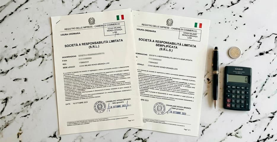 Due documenti societari italiani — SRL e SRLS — affiancati su scrivania con penna e calcolatrice: guida differenze e costi 2026